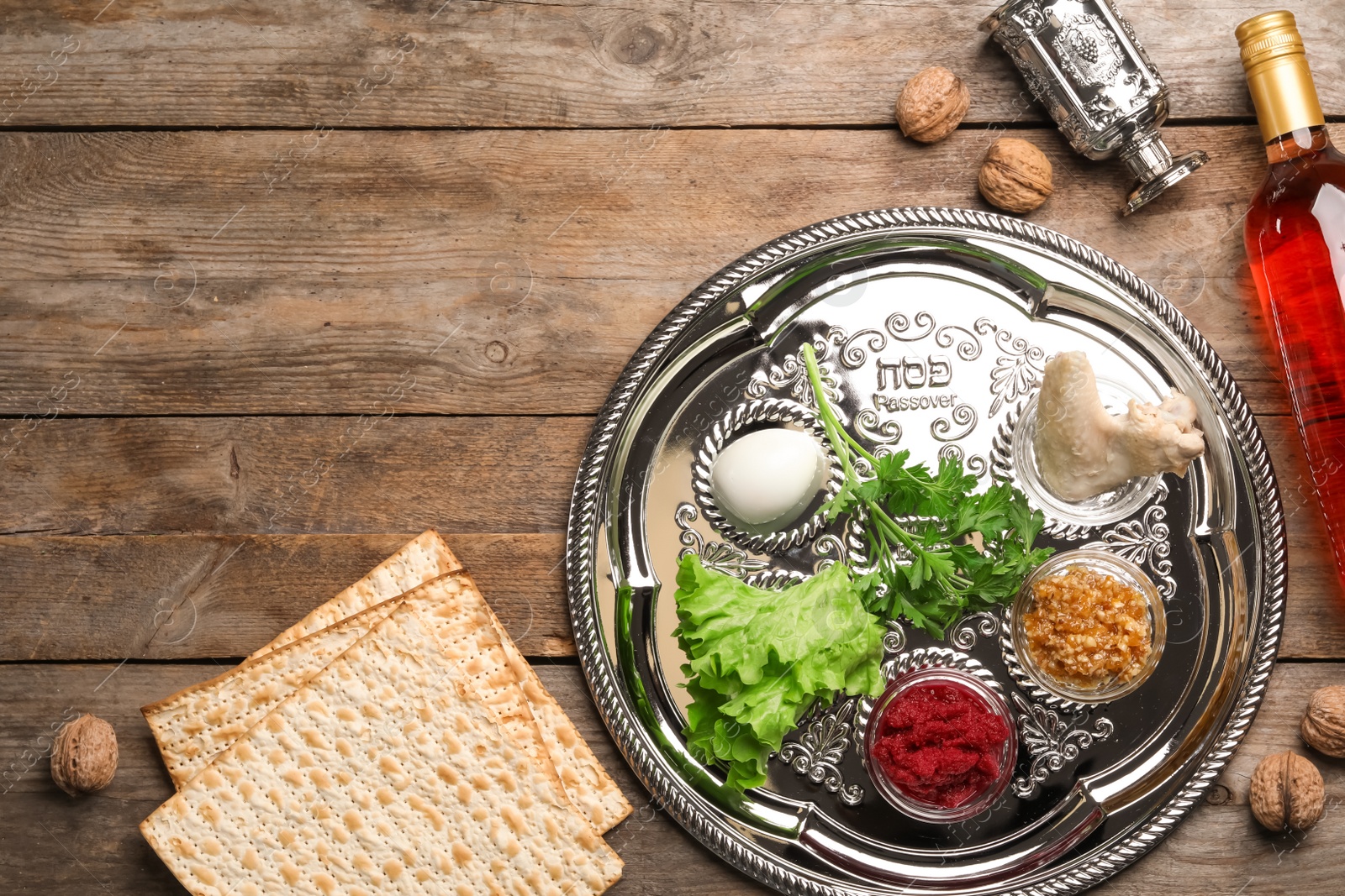 Photo of Flat lay composition with symbolic Passover (Pesach) items on wooden background, space for text