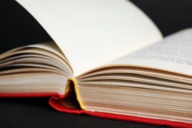 Photo of Closeup view of open book on black background