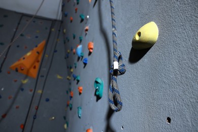 Photo of Climbing rope and wall with holds in gym