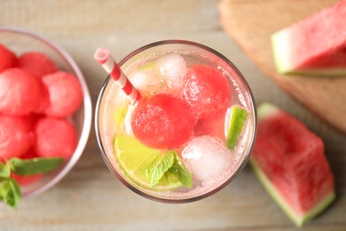 Glass of refreshing watermelon drink on wooden table, top view