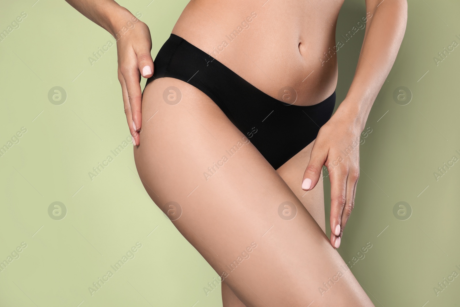 Photo of Closeup view of slim woman in underwear on light green background. Cellulite problem concept