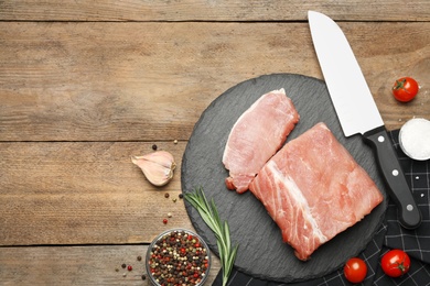 Photo of Flat lay composition with fresh raw cut meat on wooden table. Space for text