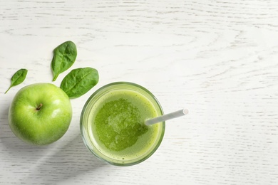 Glass with delicious detox juice and ingredients on light background, top view