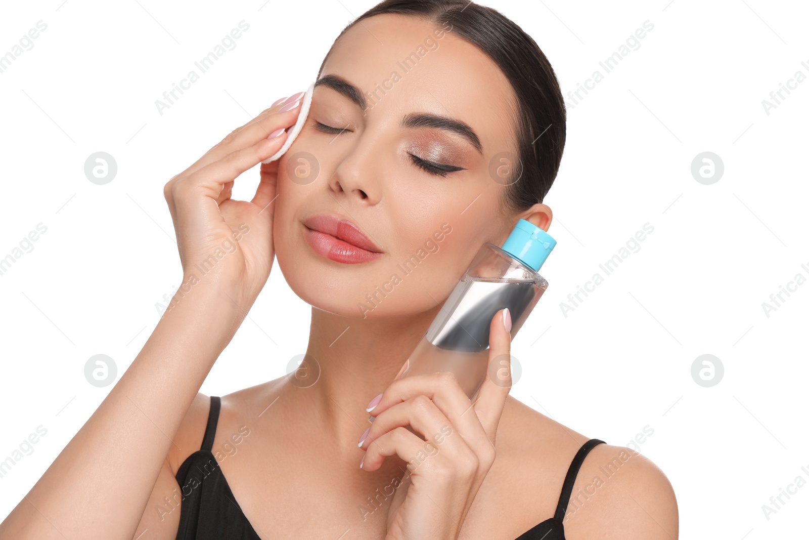 Photo of Beautiful woman removing makeup with cotton pad on white background