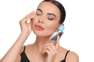 Photo of Beautiful woman removing makeup with cotton pad on white background