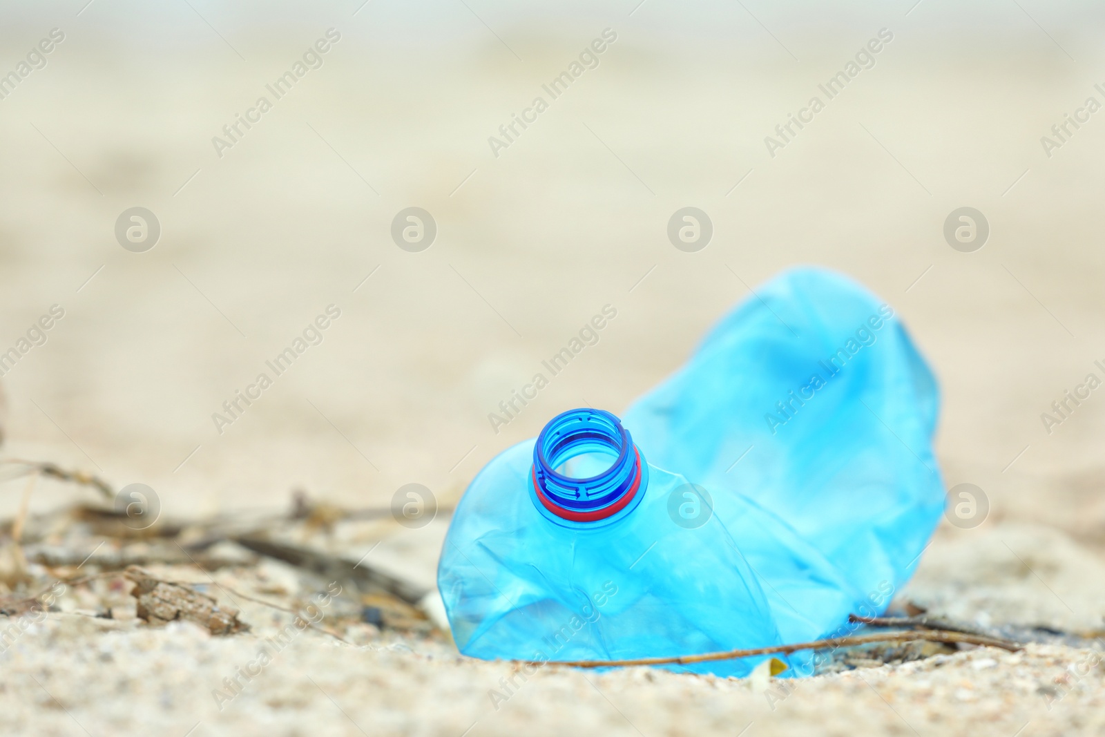 Photo of Used plastic bottle on beach, closeup with space for text. Recycling problem