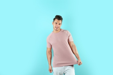 Photo of Young man in t-shirt on color background. Mockup for design