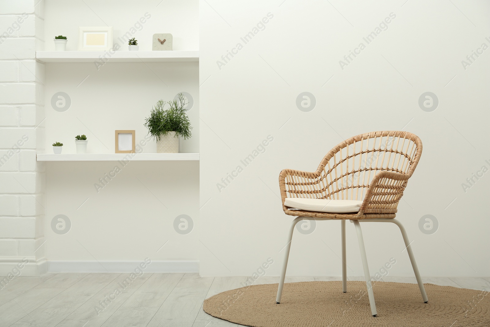 Photo of Stylish comfortable wicker armchair in light room. Space for text