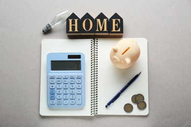 Photo of Flat lay composition with piggy bank and calculator on light grey textured background. Paying bills concept