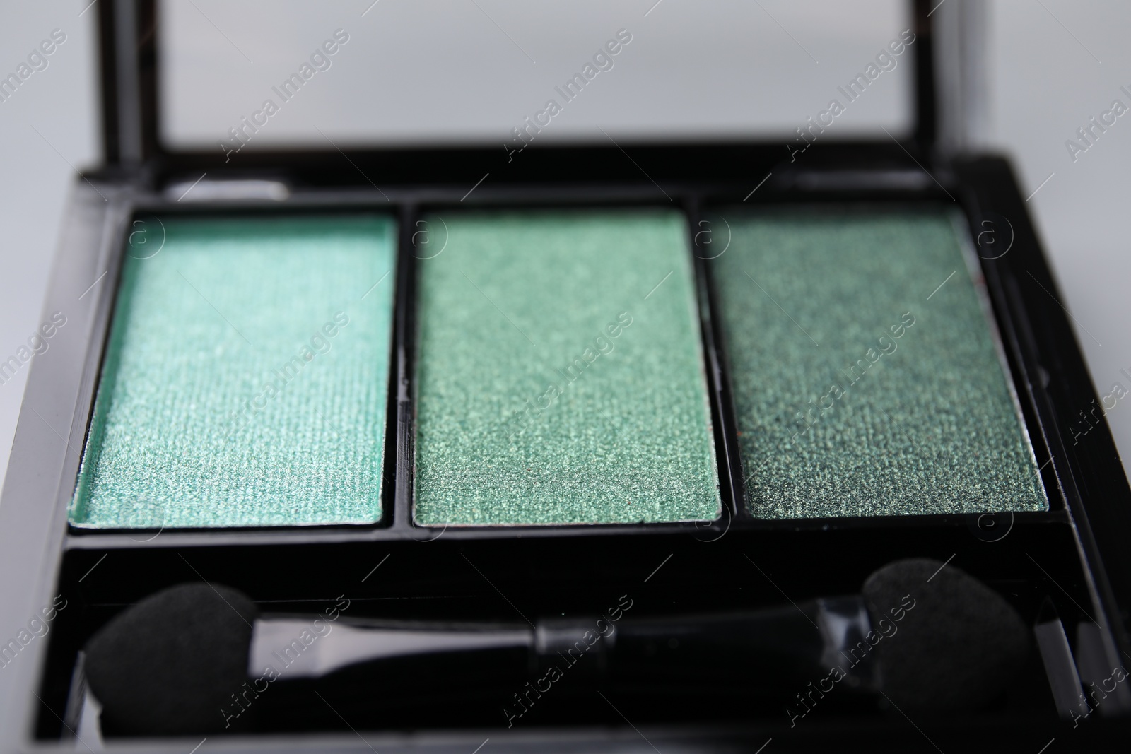 Photo of Beautiful eyeshadow palette and applicator as background, closeup. Professional cosmetic product