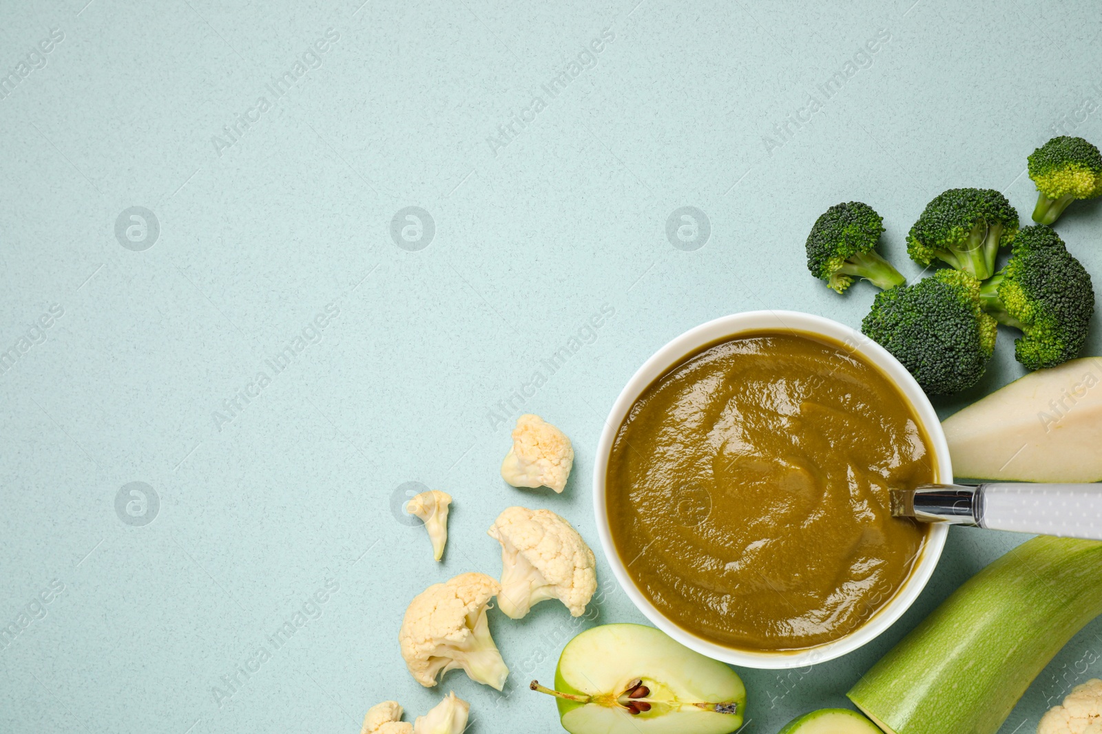 Photo of Healthy baby food and ingredients on light blue background. Space for text