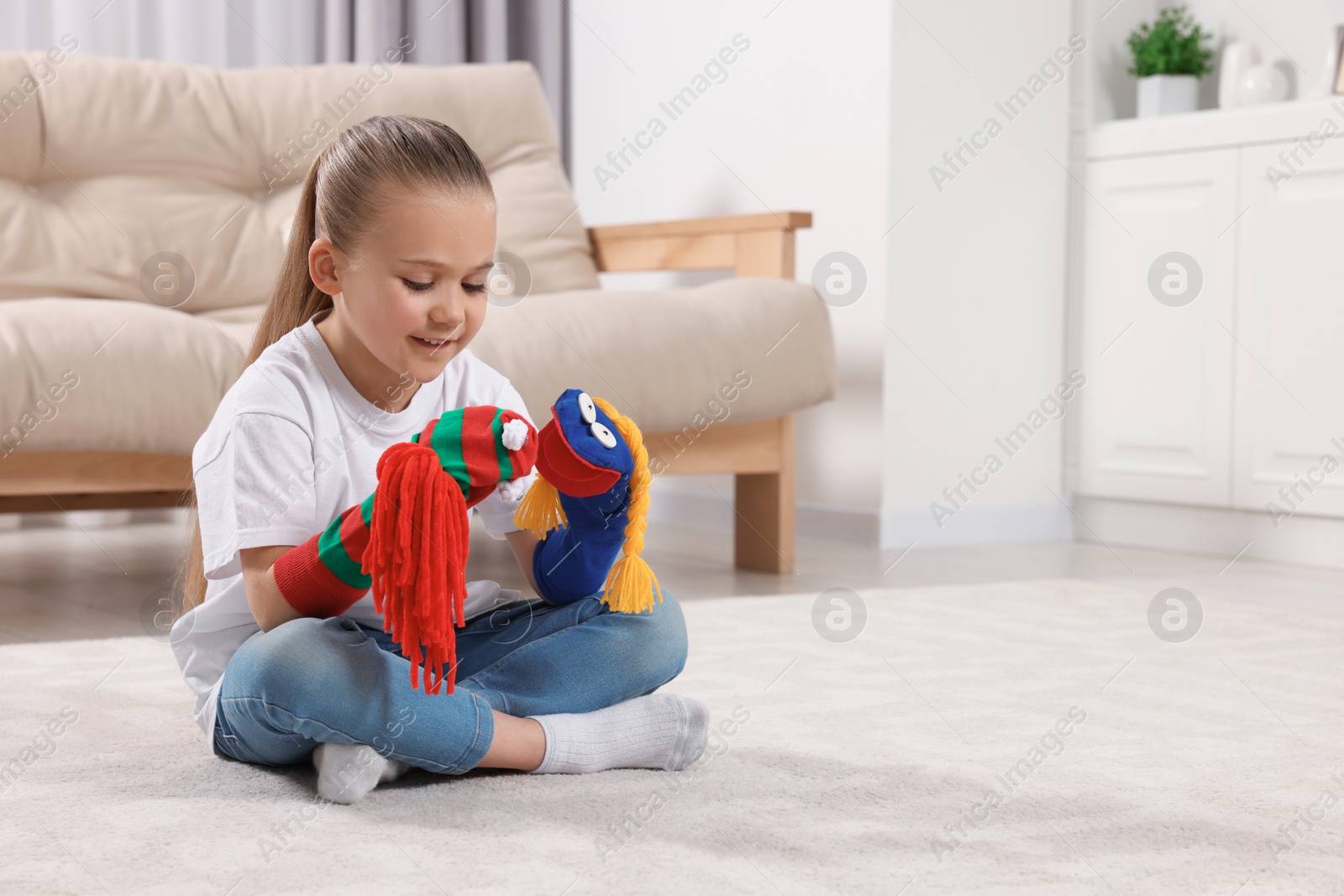 Photo of Happy daughter with funny sock puppets playing at home, space for text