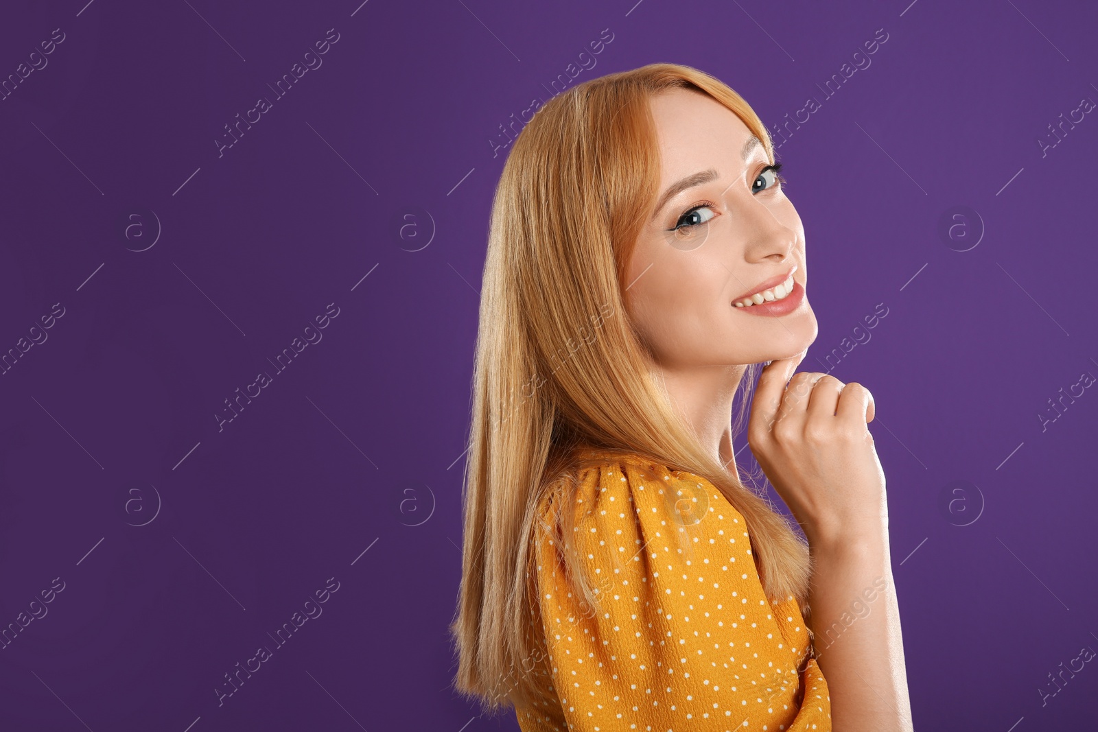 Photo of Beautiful young woman with blonde hair on purple background