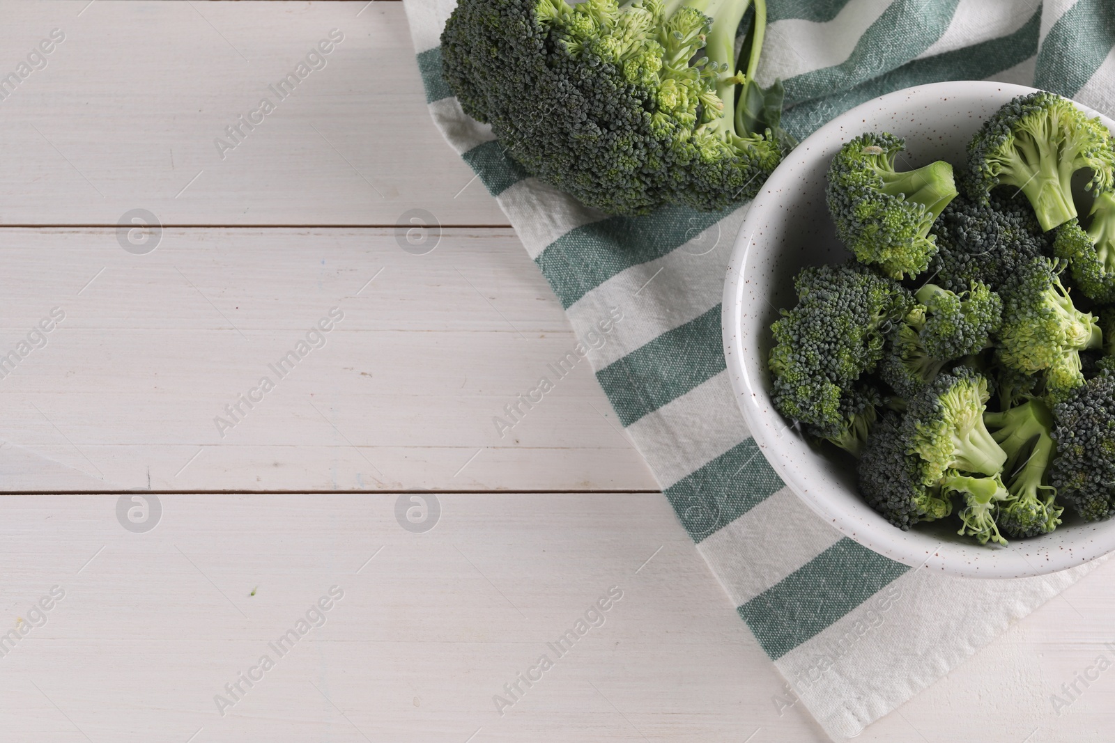 Photo of Fresh raw broccoli on white wooden table, flat lay. Space for text