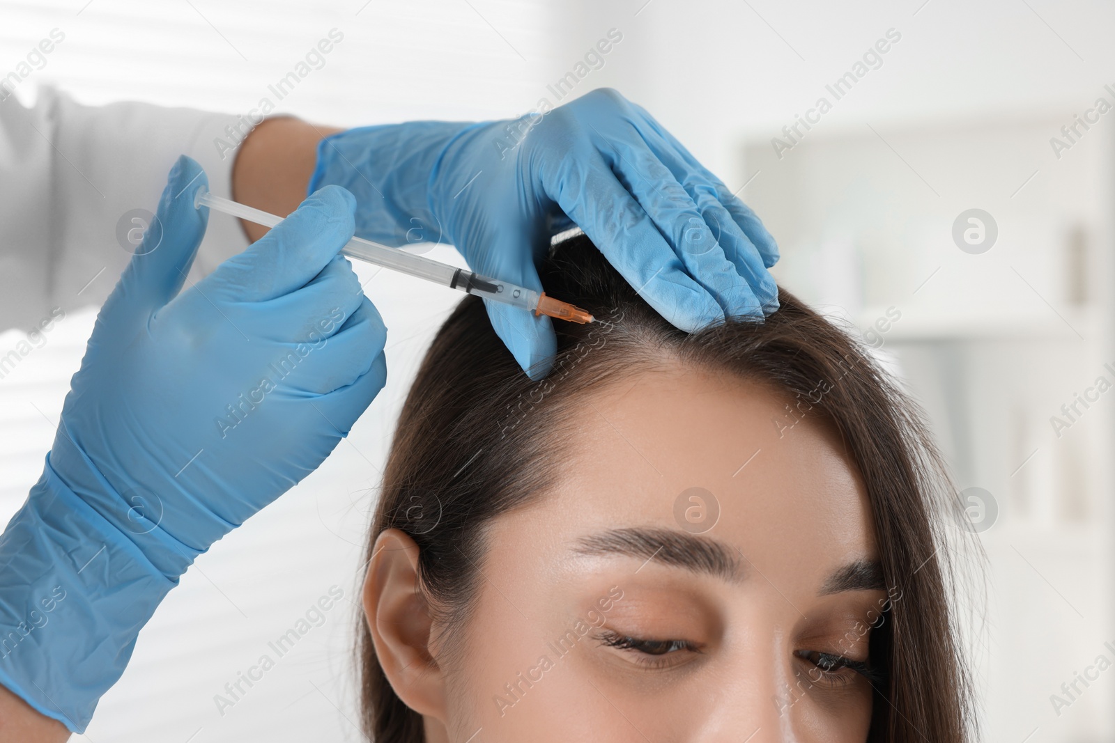 Photo of Trichologist giving injection to patient in clinic, closeup