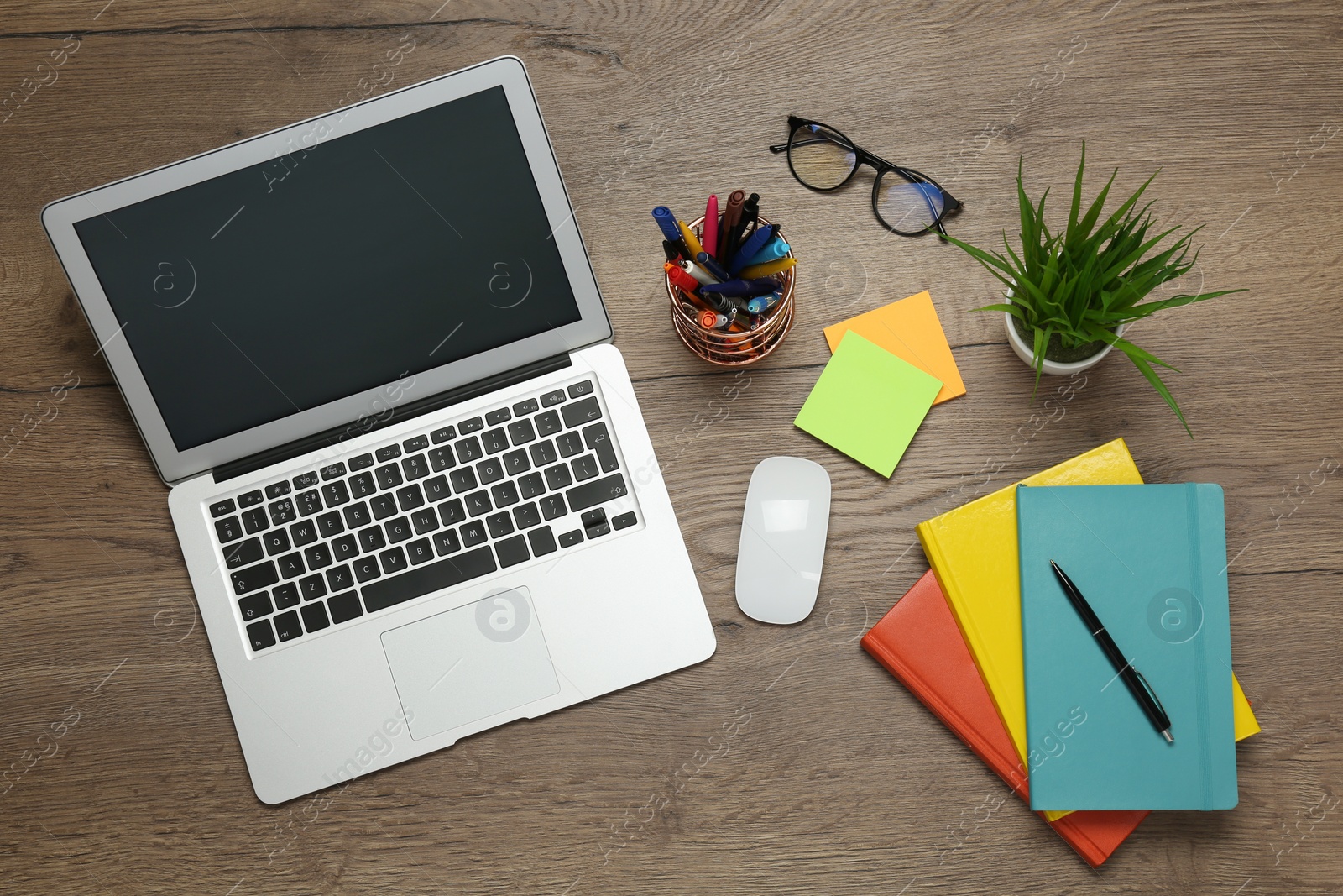 Photo of Modern laptop, glasses and office stationery on wooden table, flat lay. Distance learning