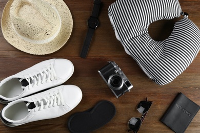 Photo of Flat lay composition with travel pillow and tourist stuff on wooden background