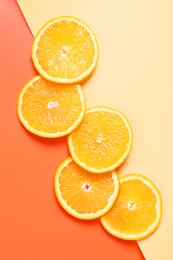 Slices of juicy orange on color background, top view