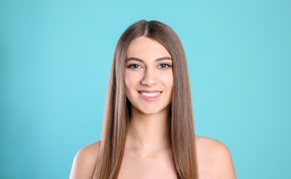 Photo of Portrait of young woman with long beautiful hair on color background