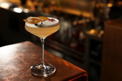 Photo of Fresh alcoholic cocktail on counter in bar. Space for text