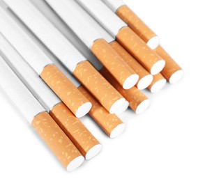 Photo of Pile of cigarettes with orange filters on white background, above view