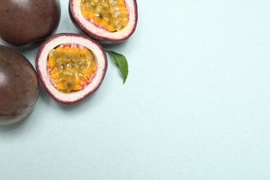 Photo of Fresh ripe passion fruits (maracuyas) with leaf on light background, flat lay. Space for text