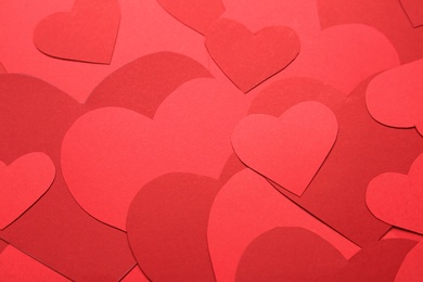 Red paper hearts as background, above view