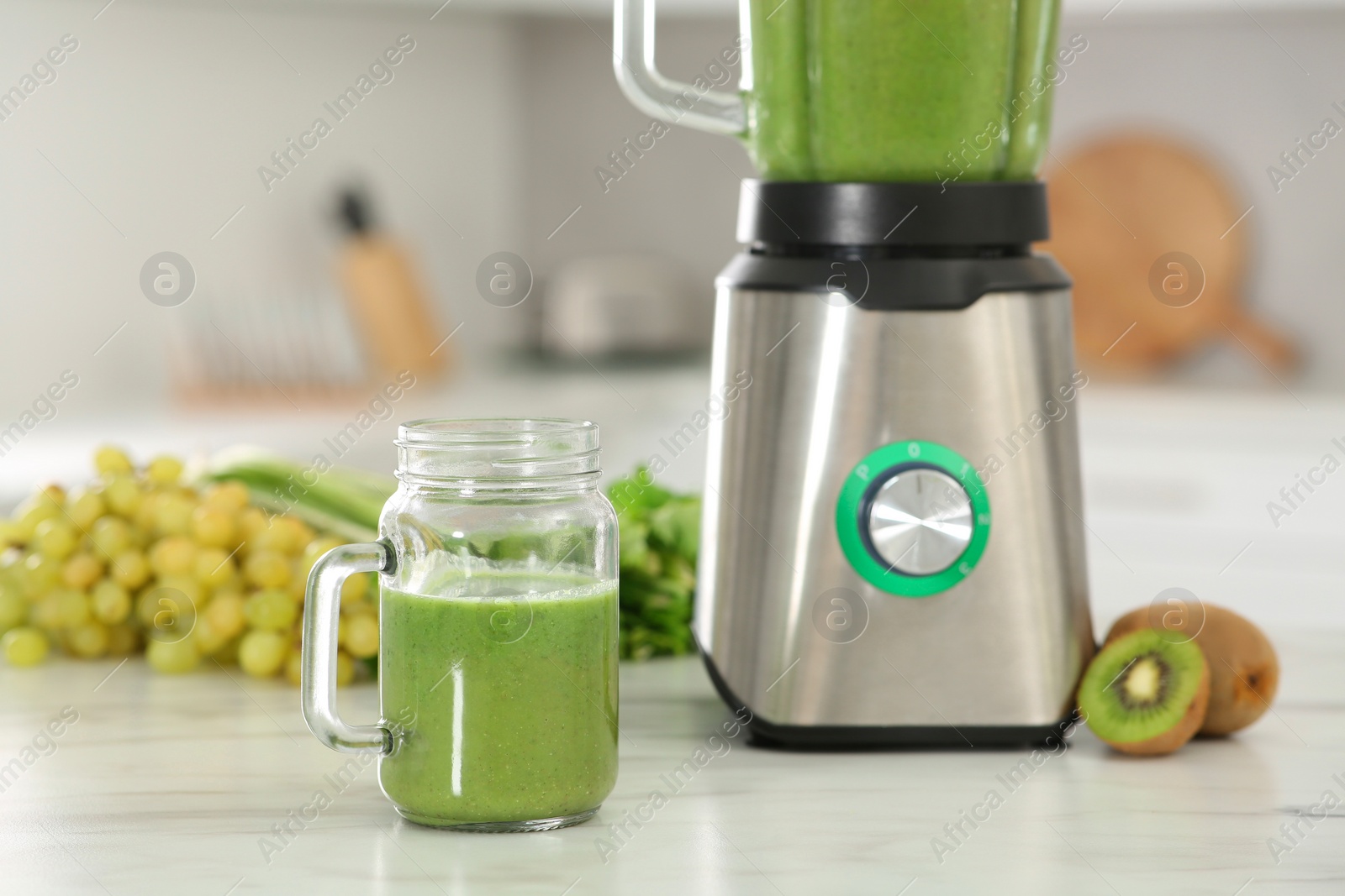 Photo of Delicious fresh smoothie and ingredients on white marble table in kitchen