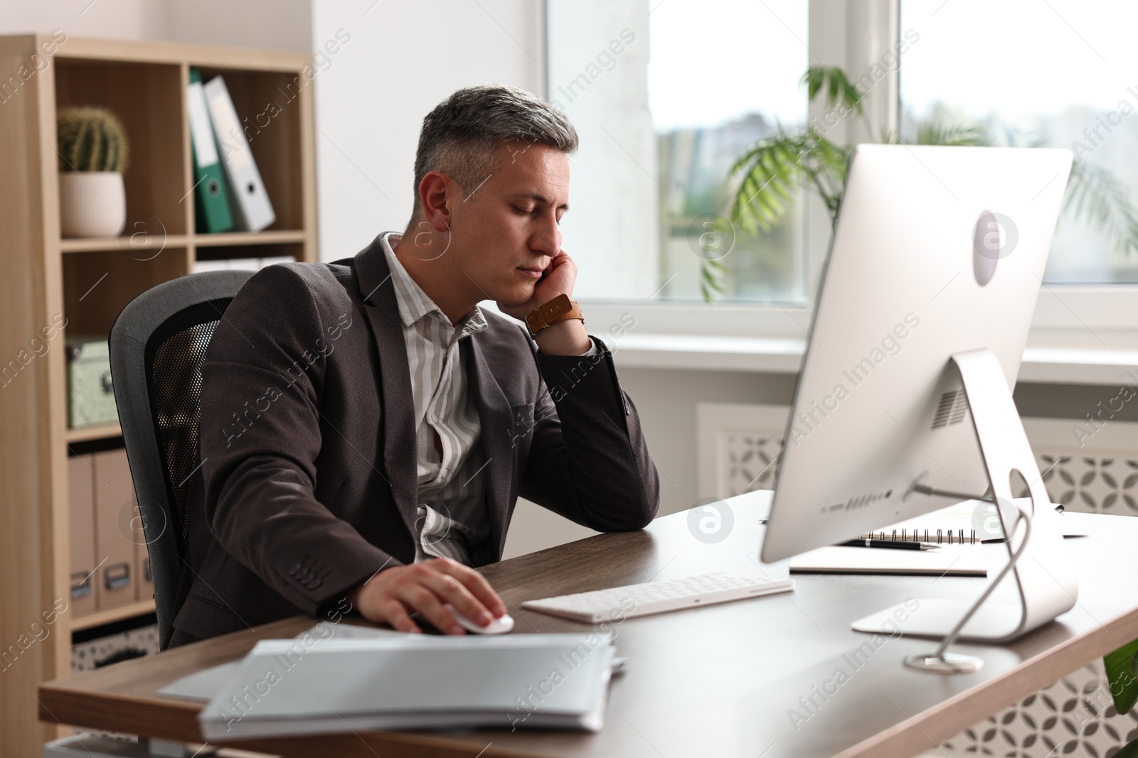 Photo of Man snoozing at wooden table in office