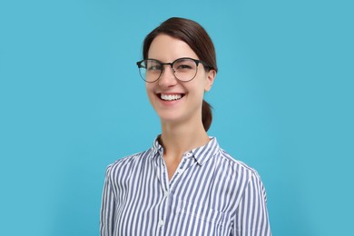 Portrait of happy secretary on light blue background