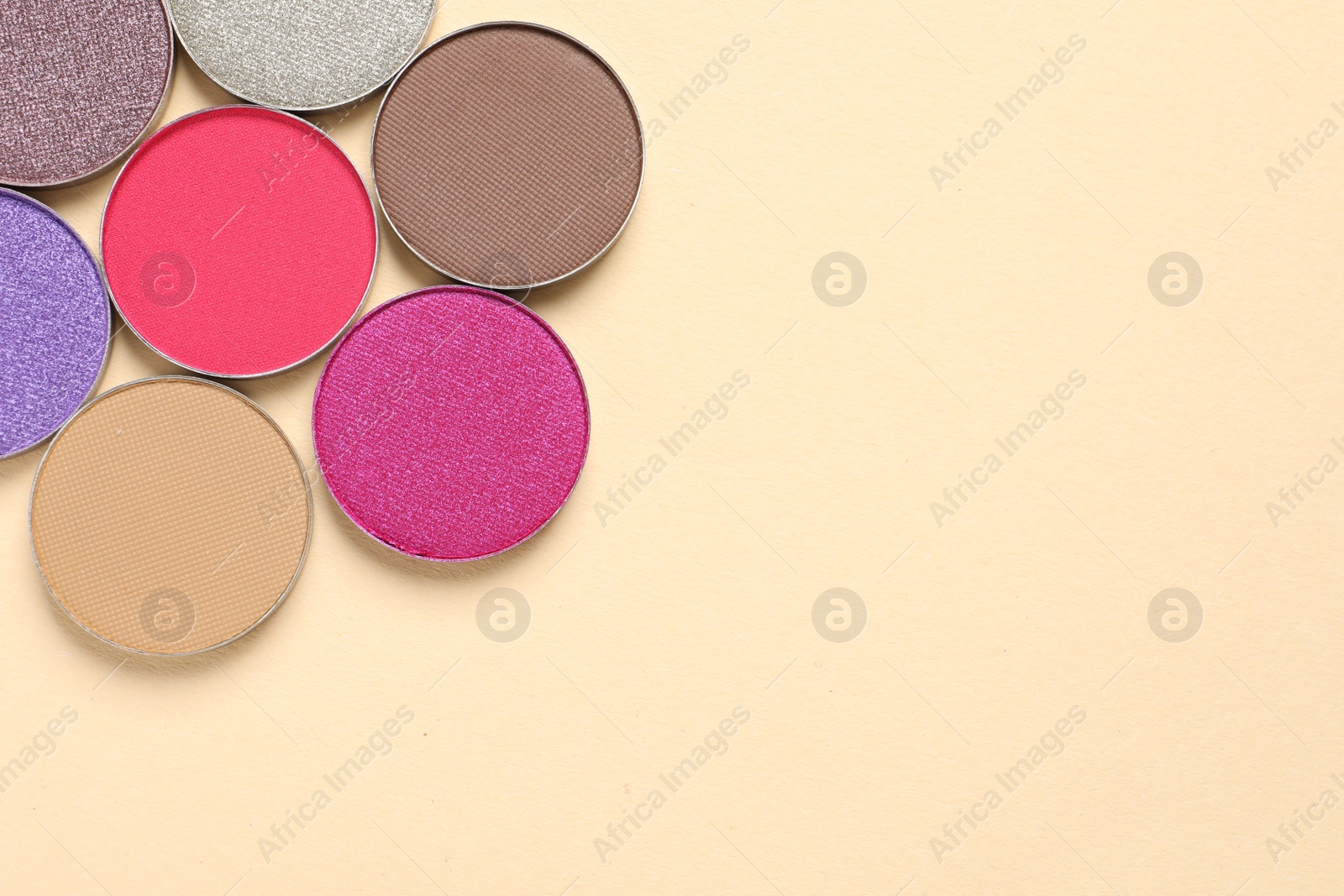 Photo of Different beautiful eye shadows on beige background, flat lay. Space for text