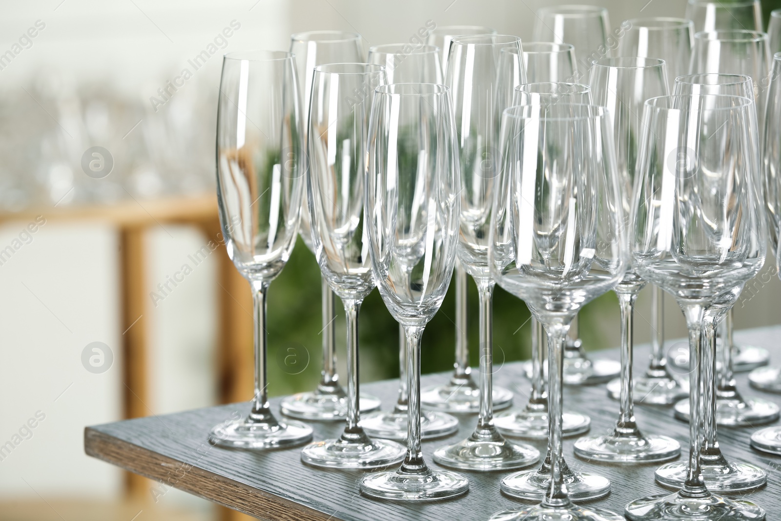 Photo of Empty glasses on wooden table against blurred background