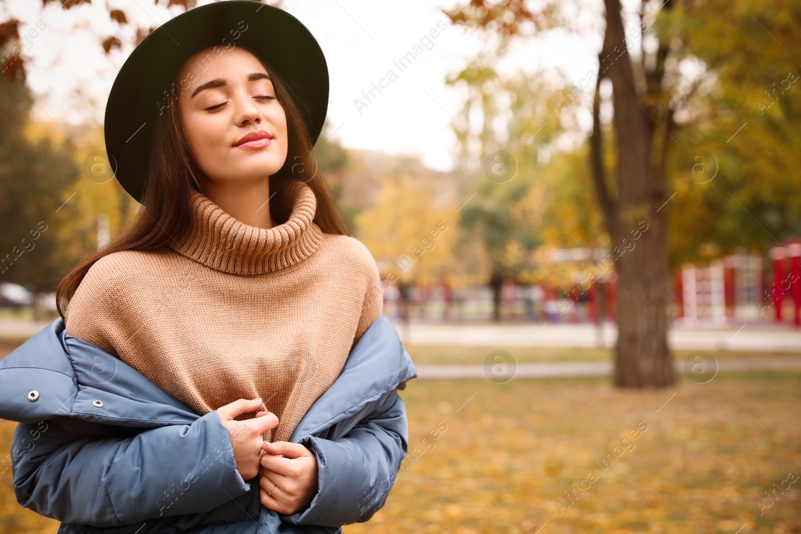 Photo of Young woman wearing stylish clothes in autumn park, space for text