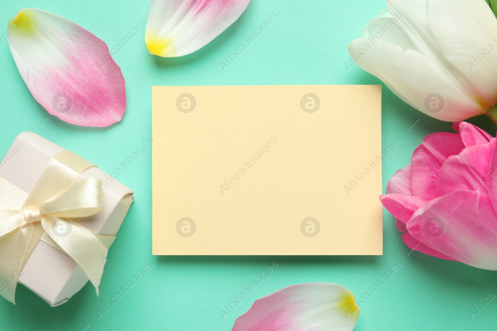 Photo of Flat lay composition of tulips and blank card on color background, space for text. International Women's Day