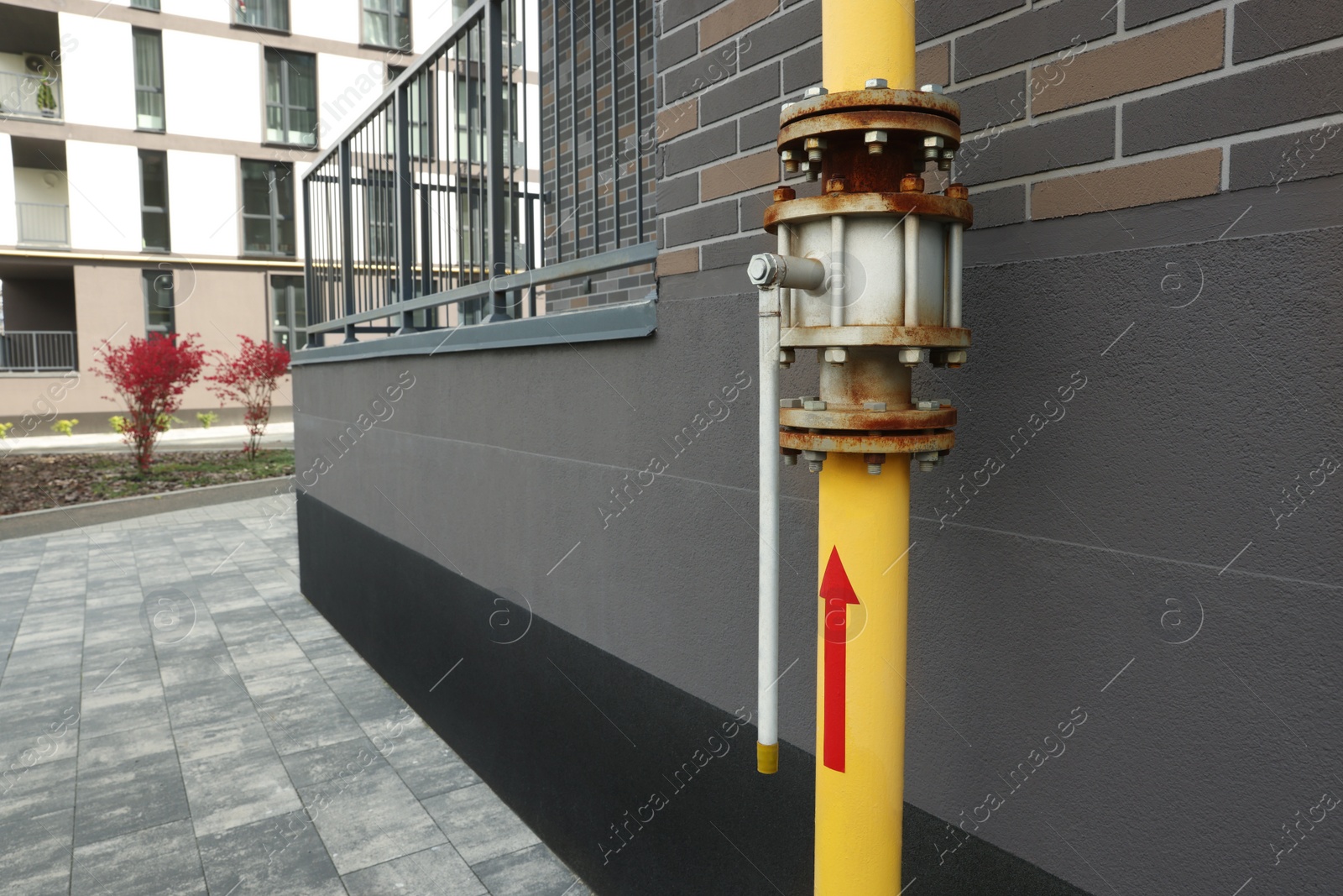 Photo of Yellow gas pipe with valve near brick wall outdoors