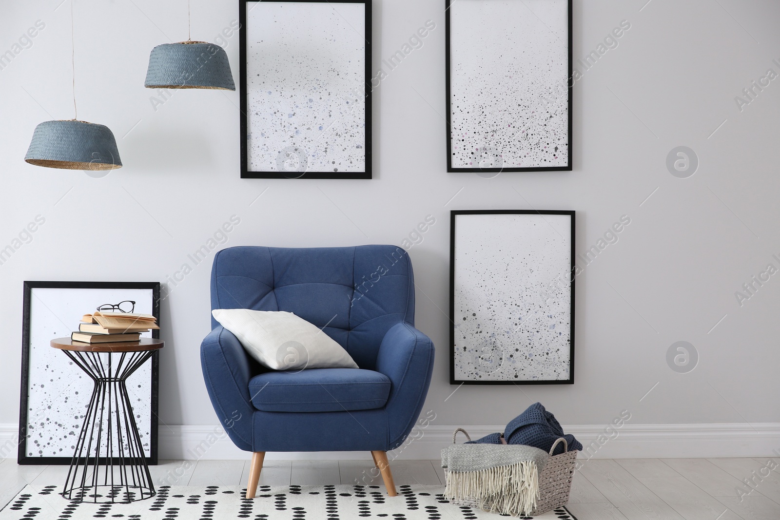 Photo of Beautiful artworks and comfortable armchair in stylish room. Interior design