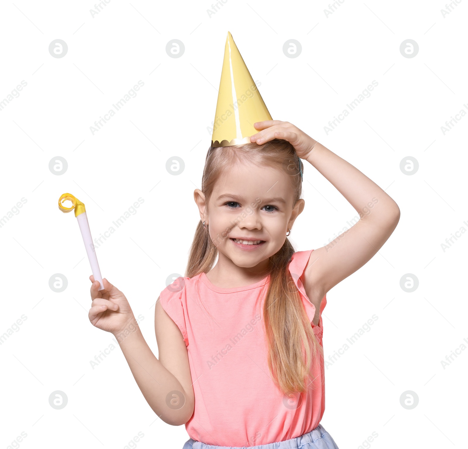 Photo of Birthday celebration. Cute little girl in party hat with blower on white background