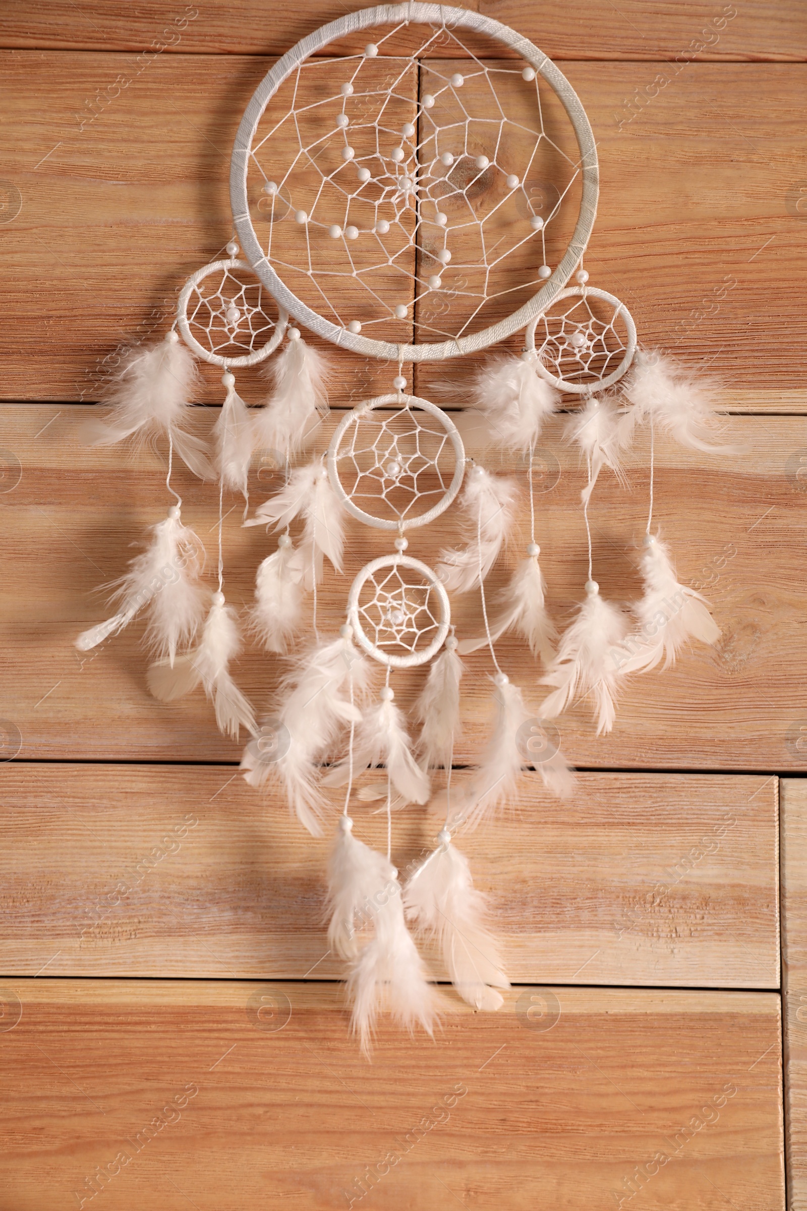 Photo of Beautiful dream catcher hanging on wooden wall