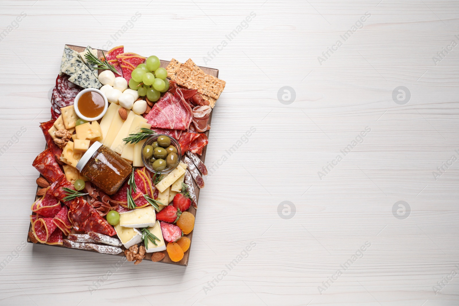 Photo of Assorted appetizer served on white wooden table, top view. Space for text