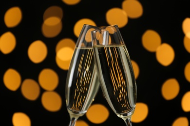 Clinking glasses of champagne against blurred lights