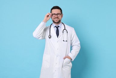 Portrait of smiling doctor on light blue background