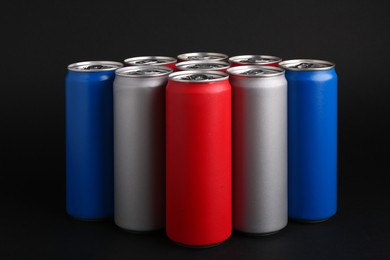 Energy drinks in colorful cans on black background