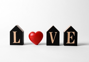 Photo of Word Love made of decorative letters and red heart on white background