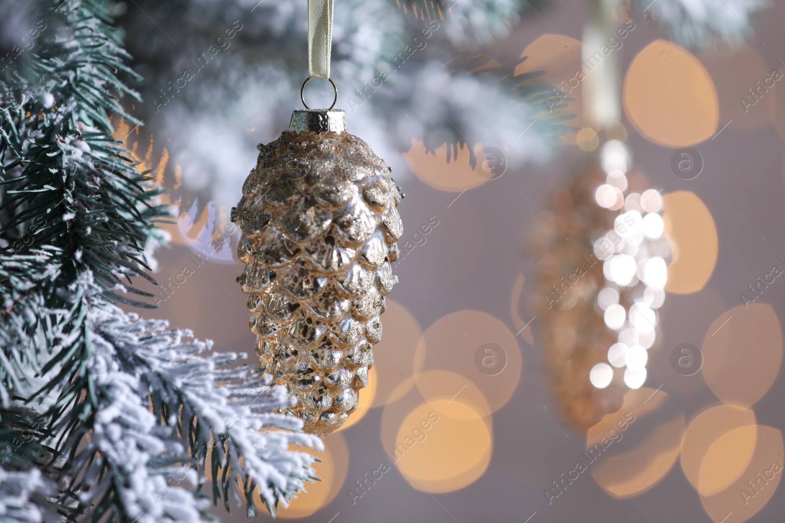 Photo of Christmas tree decorated with holiday baubles against blurred lights, closeup. Space for text