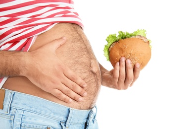 Photo of Overweight man with hamburger on white background, closeup