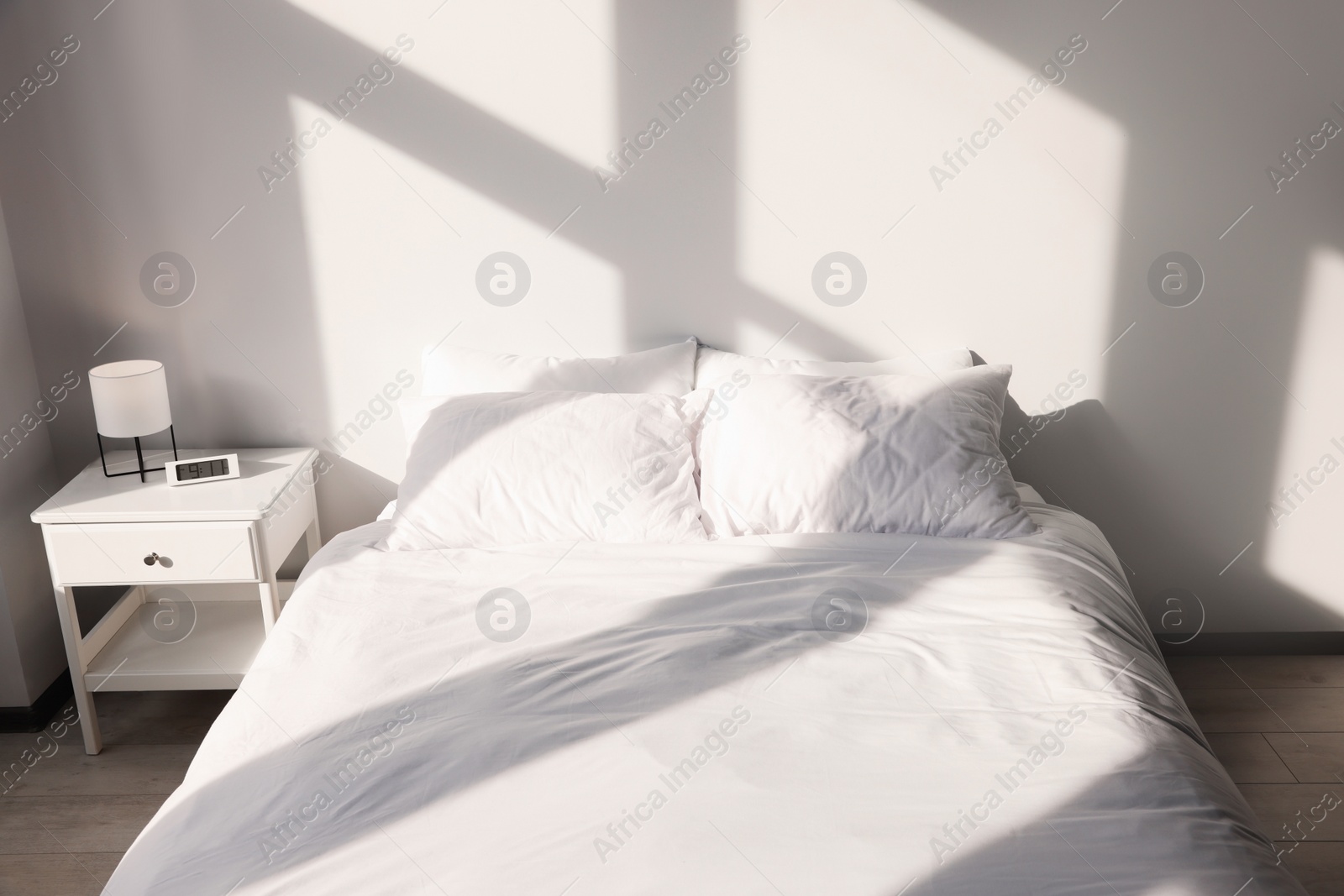 Photo of White soft pillows on bed in room