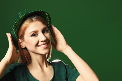 Young woman in green outfit on color background. St. Patrick's Day celebration