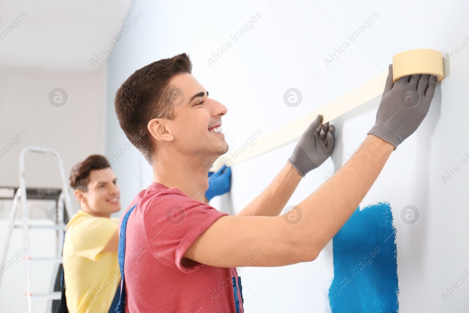 Photo of Male decorators working with tape indoors