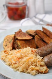 Photo of Plate with sauerkraut, sausages and potatoes on table, closeup