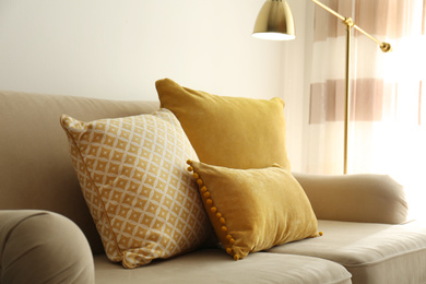 Three pillows on sofa near wall in room. Interior design